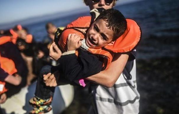 Un pequeño llega a las costas griegas en una barcaza hinchable/ AFP