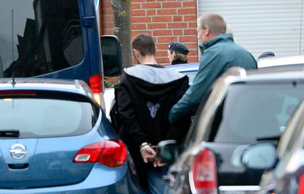 Agentes de Policía alemanes llevan esposado a uno de los detenidos en Alsdorf, cerca de Aachen (ROBERTO PFEIL / AFP)
