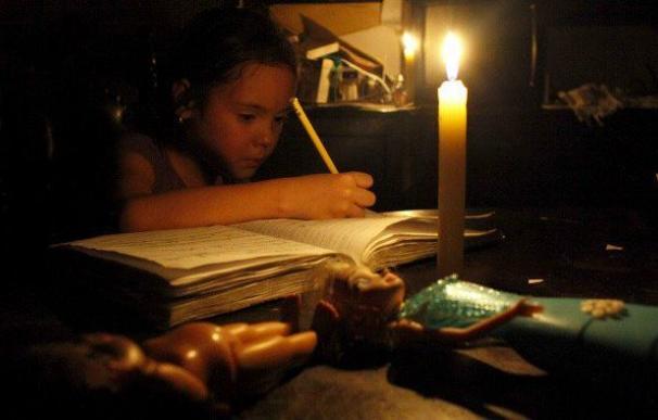 Una niña, en un hogar sin luz de Venezuela.