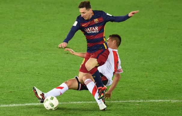 Barcelona forward Lionel Messi (top) is tackled by
