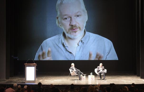 Wikileaks founder Julian Assange (on then screen)