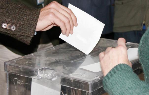 Un votante deposita la papeleta en la urna.