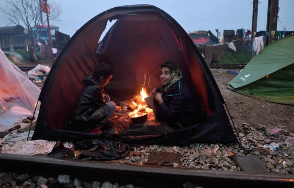Niños se calientan en una tienda en el campo de Idomeni, cerca de la frontera de Grecia y Macedonia
