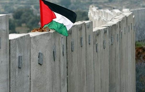 Una bandera palestina ondea desafiante sobre el muro de Cisjordania