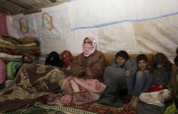 Una familia tirita de frío en el interior de una tienda en un campo de refugiados /AFP