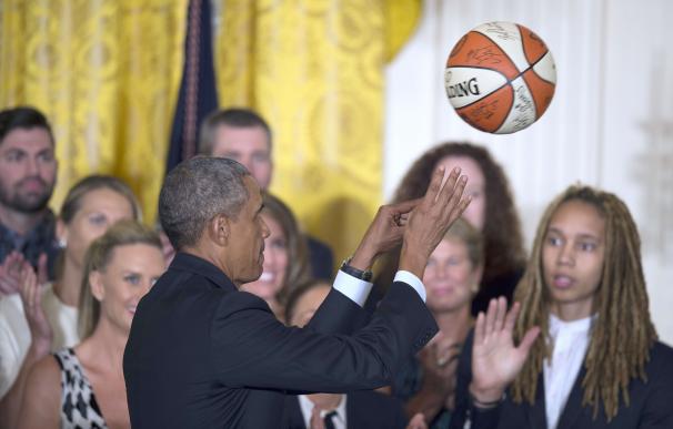 US President Barack Obama throws a signed basketba