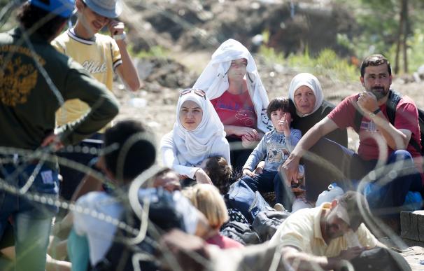 Inmigrantes esperan en la frontera griega para entrar a Macedonia.