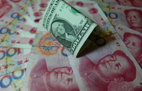 Yuan banknotes and US dollars are seen on a table