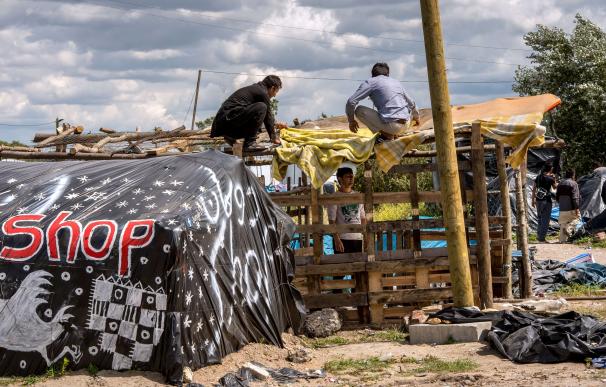 Migrants build a makeshift shelter at a site dubbe