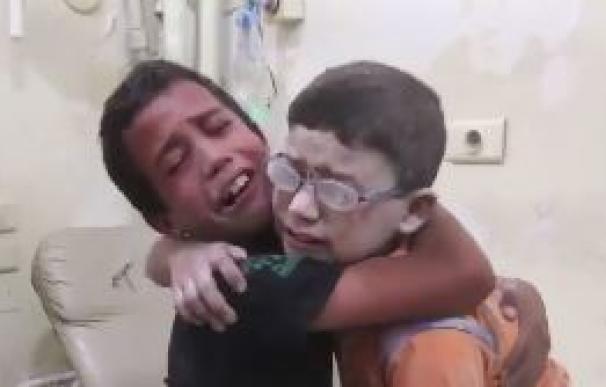 Dos niños lloran desconsolados al saber que su hermano ha muerto en un bombardeo en Alepo