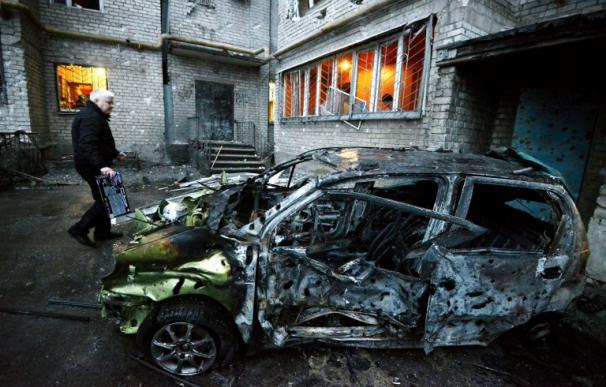 Un hombre junto a su coche destrozado por un bombardeo en Donetsk, Ucrania