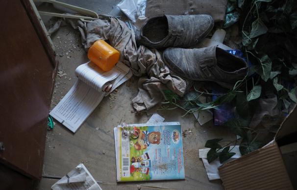 Dibujos, flores, juguetes, cuadernillos de caligrafía, se mezclan entre los escombros del colegio