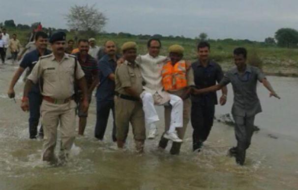 Crítican a un político indio por ser llevado en brazos por dos policías en una zona inundada