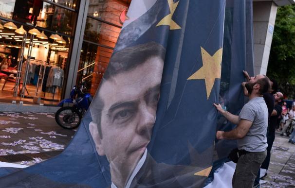 Retirada de una bandera de la UE con la imagen de Tsipras