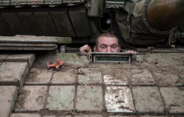 Un ucraniano mira por encima de un tanque cerca de la base de Peski, Donetsk
