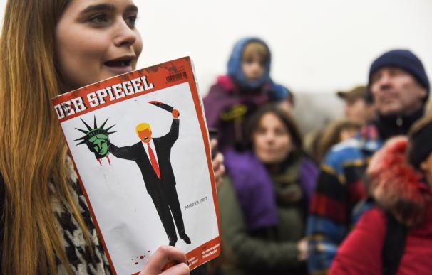 Una joven lleva en su mano la portada de 'Der Spiegel'