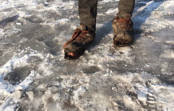 Un refugiado sin hogar en Belgrado soporta un frío extremo con el calzado roto (Tatjana Ristic/Save the Children)