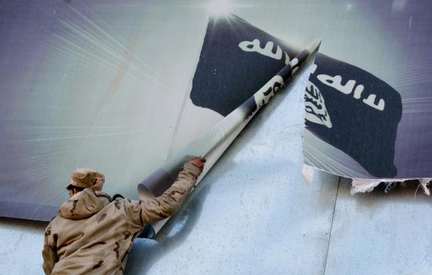 Un soldado iraquí retira una bandera del EI en Mosul