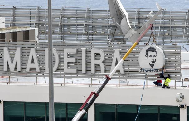 Los operarios colocan la placa con el rostro de Ronaldo en el aeropuerto de Madeira.