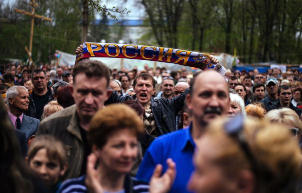 Un hombre grita consignas y sostiene una bufanda que reza 'Rusia' durante una marcha prorrusa en Lugansk