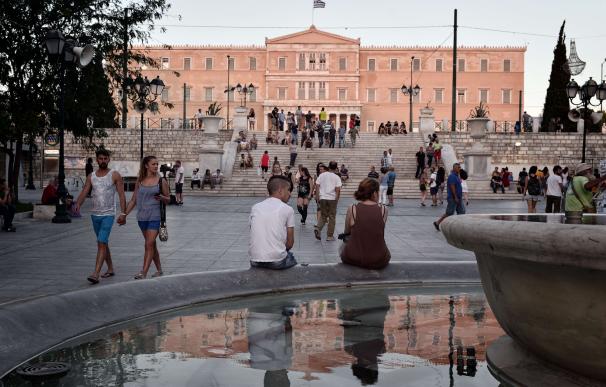 People sit outside the Greek parliament in Athens