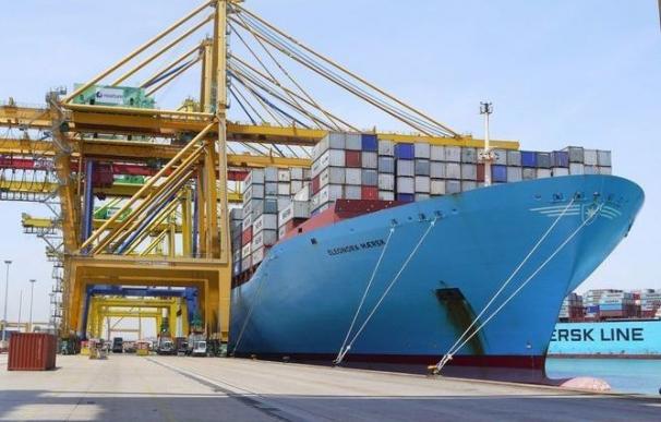 Estibadores cargan contenedores en un barco en el puerto de Valencia