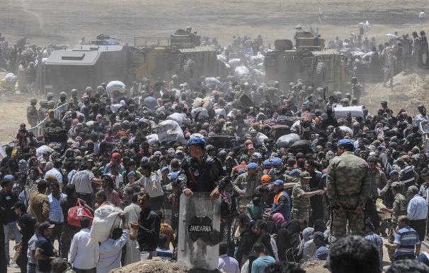 Refugiados sirios esperan transporte después de cruzar hacia Turquía desde la ciudad siria de Tal Abyad