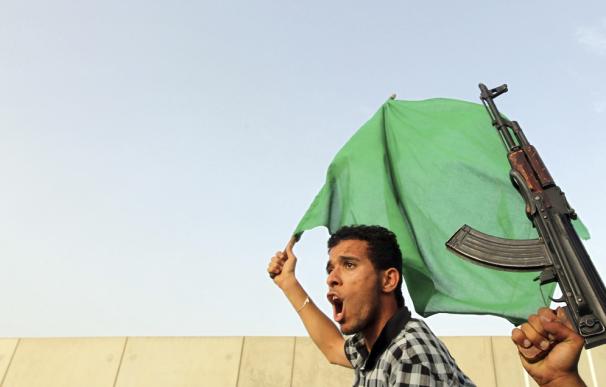Unos hombres, uno de ellos armado, participan en una manifestación de seguidores del líder libio, Muamar el Gadafi, en Trípoli.
