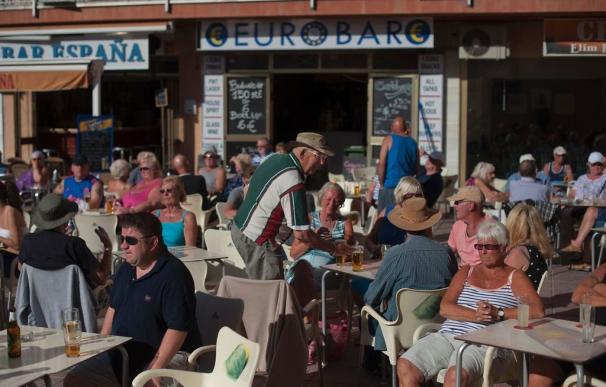 Varios turistas disfrutan del sol en la terraza de un bar de Benalmádena (Foto: AFP)