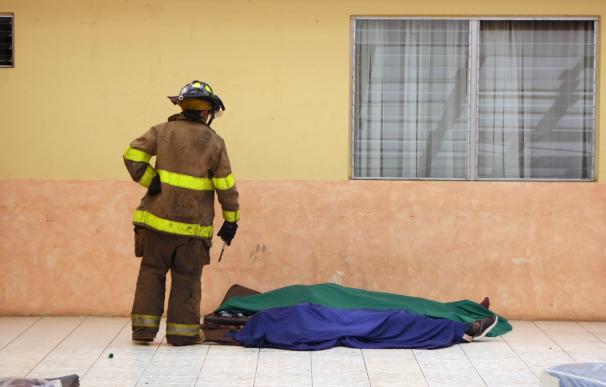 Un bombero mira a dos de las víctimas del Hogar Seguro (Bomberos Voluntarios de Guatemala)