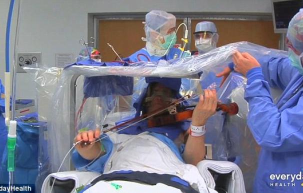 Un violinista toca su instrumento mientras es operado de un temblor
