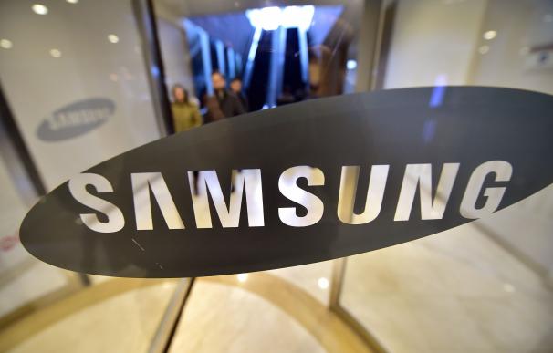 People walk past the logo of Samsung Electronics a