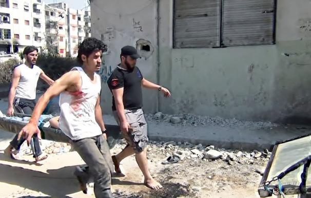 Varias personas cargan a un herido por los bombarderos en Siria