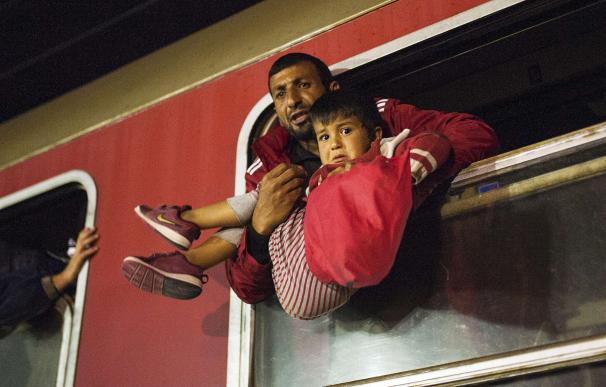 A man holds a child in a train heading to Serbia f