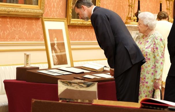 Los Reyes regalan a Isabel II facsímiles de postales de Alfonso XIII, Victoria Eugenia y del Libro de Horas de Felipe II