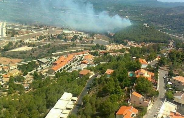 Medios aéreos y terrestres trabajan en la extinción de un incendio en Gilet que obliga a desalojar 150 casas