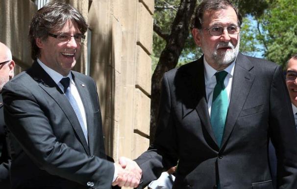 El presidente de la Generalitat, Carles Puigdemont (i), y el del Gobierno, Mariano Rajoy (d), se saludan a su llegada hoy al Museo Nacional de Arte de Cataluña (MNAC) (EFE/Toni Albir)