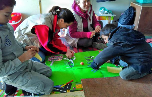 Sara Polo y otra compañera de Save the Children jugando con niños llegados a Lesbos