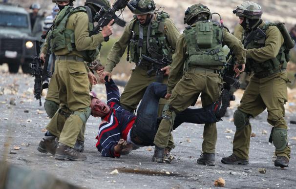 Soldados israelíes llevando en volandas a un ciudadano palestino/AFP