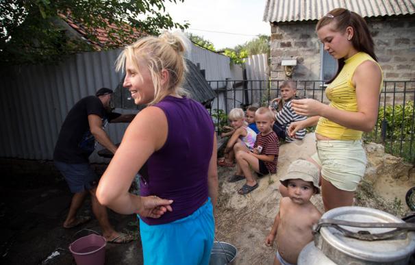 Niños con sus madres recogen agua en Avdiyvka, cerca de Donetsk, el 22 de agosto