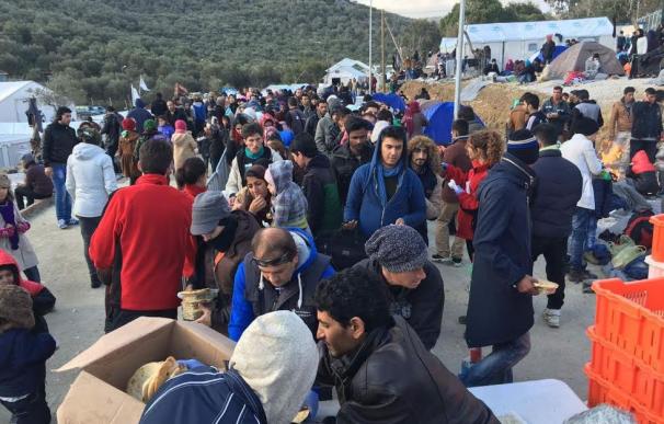 Fila de migrantes llegados a Lesbos que esperan su ración de comida