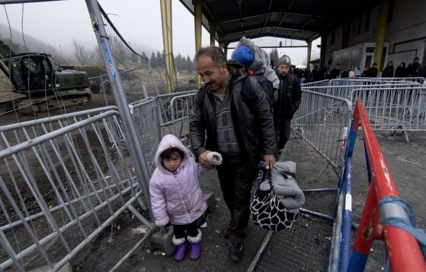 Migrants line up at a transit area between Austria