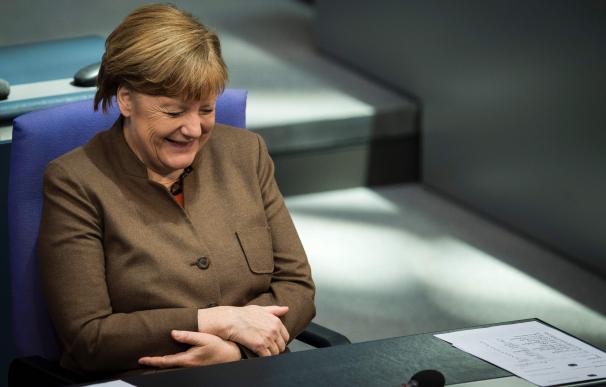German Chancellor Angela Merkel laughs while atten