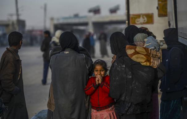 Una niña siria espera junto a su familia en el paso fronterizo con Turquía
