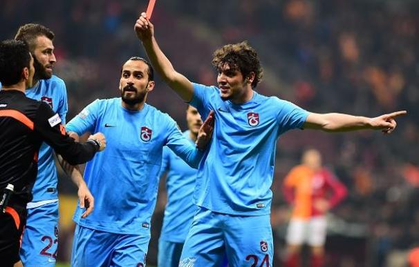 Un futbolista del Trabzonspor saca la tarjeta roja al árbitro antes de ser expulsado / AFP.