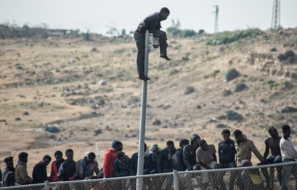 Varios inmigrantes en el muro de Melilla (AFP)