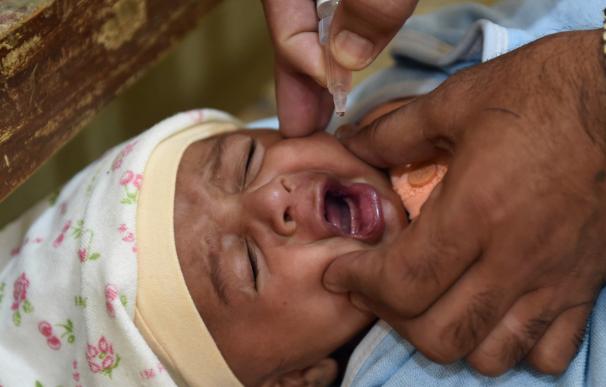 A Pakistani health worker administers polio drops