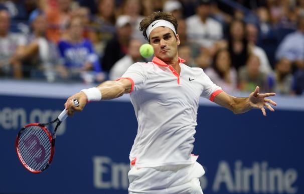 Roger Federer of Switzerland hits a return to John