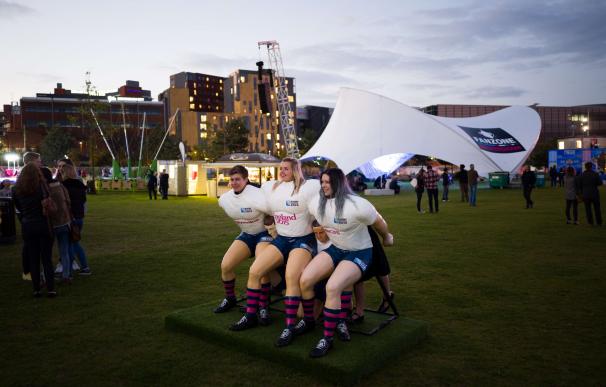 Rugby fans pose in a plastic scrum as they wait to