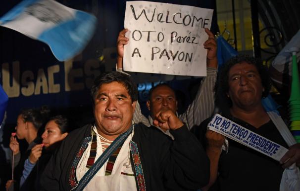men hold signs reading "Welcome Otto Perez to Pavo